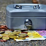 a cash box with coins and a key - How to Get Ahead Financially by deified progress