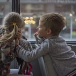 a boy and girl sitting in a bus