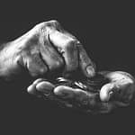 a person holding coins in their hands Personal Savings Rate Soars
