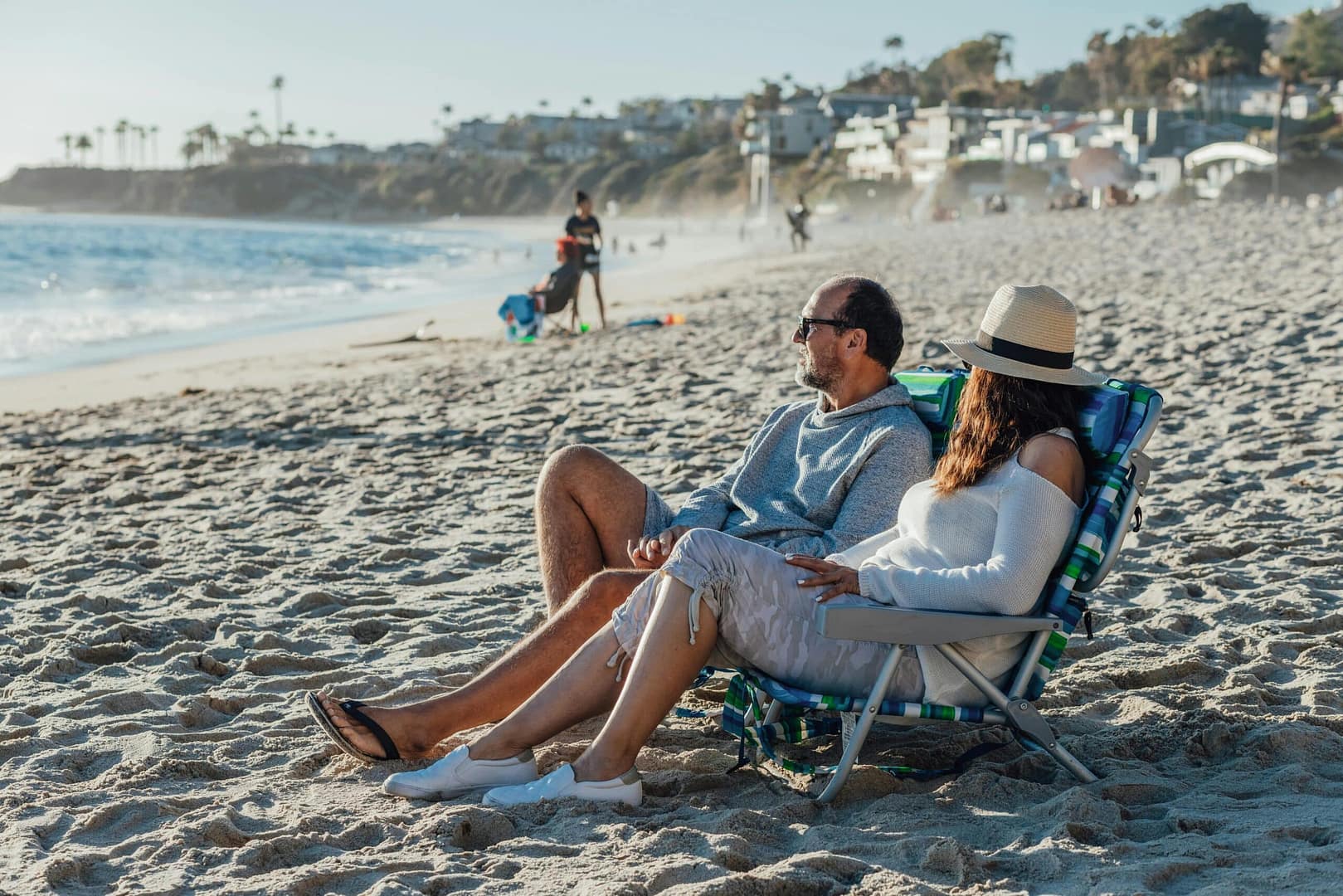 a man and woman sitting on a beach